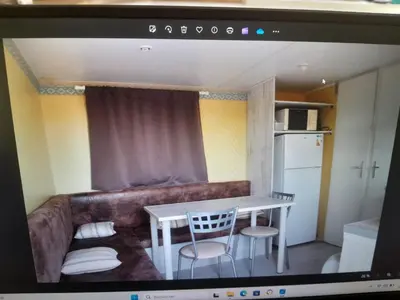 a living room with a couch and a table and chairs at Petit chalet in Pianottoli-Caldarello