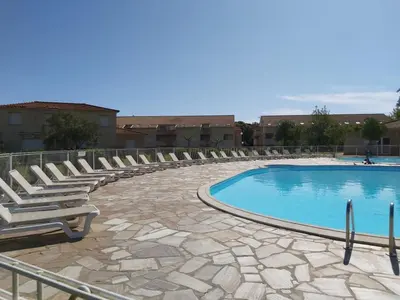 a swimming pool with lounge chairs next to a building at Ville melody in San-Nicolao
