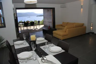a dining room with a table and a couch at Résidence Affasciata in Porto-Vecchio