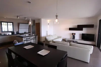 a kitchen and living room with a table and a couch at Résidence Affasciata in Porto-Vecchio