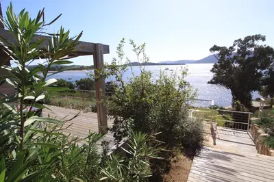 a wooden deck with a view of the water at Résidence Affasciata in Porto-Vecchio