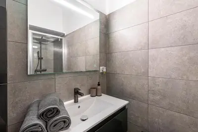 a bathroom with a sink and a mirror at L'Ornano - Maison climatisée avec piscine in Grosseto-Prugna