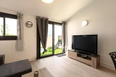 a living room with a flat screen tv and a large window at L'Ornano - Maison climatisée avec piscine in Grosseto-Prugna