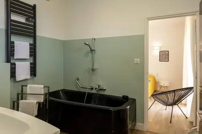 a bathroom with a black tub in a room at Villa Jeanne in Linguizzetta