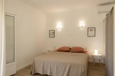 a bedroom with a bed and two lights on the wall at Villa Jeanne in Linguizzetta
