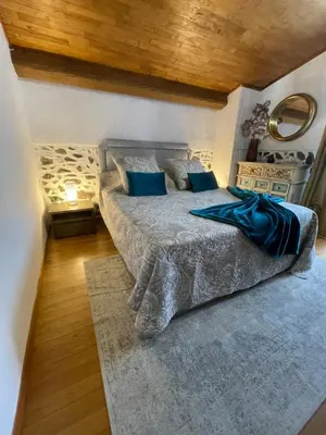 a bedroom with a large bed with blue pillows at a stalla in Valle d'Alesani