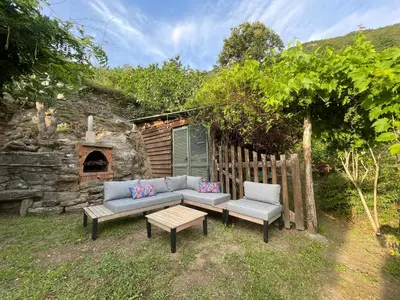 a couch and two chairs in a yard with a fireplace at a stalla in Valle d'Alesani