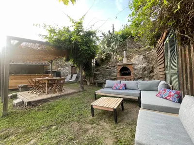 a backyard with a couch and a table and a fireplace at a stalla in Valle d'Alesani