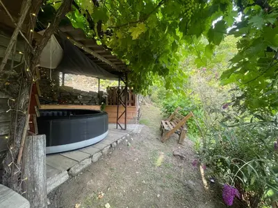 a building with a hot tub next to a bench at a stalla in Valle d'Alesani