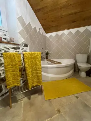 a bathroom with a sink and a toilet and yellow towels at a stalla in Valle d'Alesani