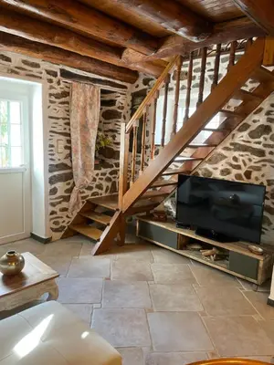 a living room with a tv and a staircase at a stalla in Valle d'Alesani