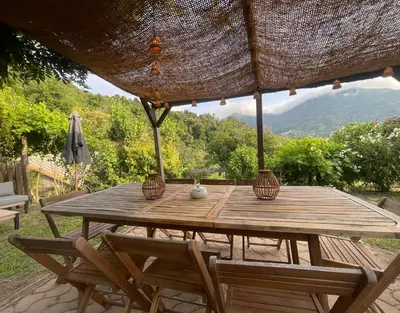 a wooden table with two chairs and an umbrella at a stalla in Valle d'Alesani