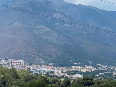 a view of a city with mountains in the background at Location très agréable T2 neuf corte in Corte