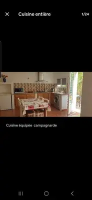 a picture of a kitchen with a table and a room at Rez de villa avec jardin in Porto-Vecchio