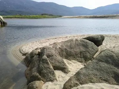 a group of rocks on the shore of a body of water at T2 400m plages et commerces excellent rapport qualité prix! in Propriano