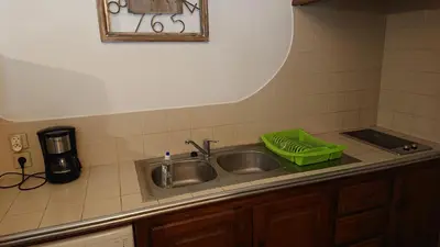 a kitchen sink with a green basket on it at T2 400m plages et commerces excellent rapport qualité prix! in Propriano