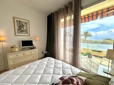 a bedroom with a large window with a view of the ocean at Appartement 2 pièces Le Versailles Ajaccio Sanguinaires in Ajaccio
