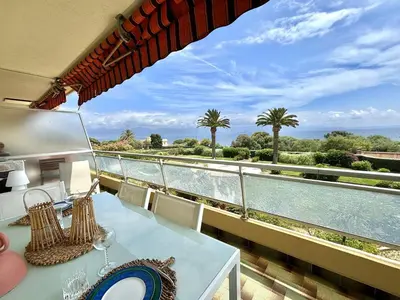a balcony with a table and a view of the water at Appartement 2 pièces Le Versailles Ajaccio Sanguinaires in Ajaccio