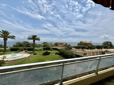 a balcony with a view of a pool and palm trees at Appartement 2 pièces Le Versailles Ajaccio Sanguinaires in Ajaccio