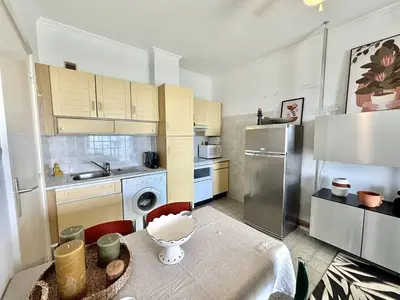 a small kitchen with a table and a refrigerator at Appartement 2 pièces Le Versailles Ajaccio Sanguinaires in Ajaccio