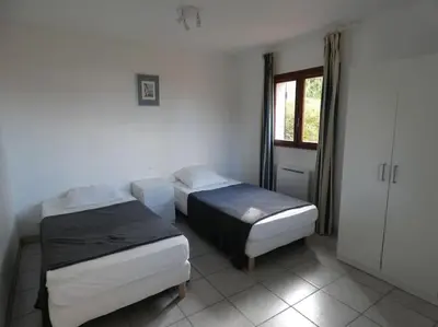 two beds in a room with a window and a door at Corsicadream cupabia, appartement dans villa proche Porticcio, vue mer, piscine in Pietrosella