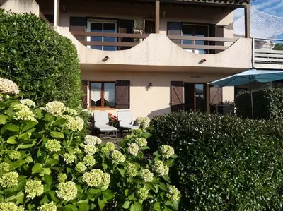 a building with a bunch of flowers in front of it at Corsicadream cupabia, appartement dans villa proche Porticcio, vue mer, piscine in Pietrosella