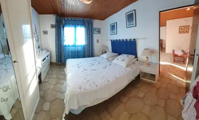 a bedroom with a large bed and a bathroom at Appt cosy rez de villa in Furiani