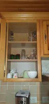 a cupboard filled with bowls and other kitchen items at Appt cosy rez de villa in Furiani