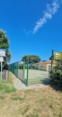 a tennis court with a fence in a field at Limiria Studio in Santa-Maria-Poggio