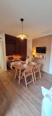 a dining room with a table and a kitchen at Limiria Studio in Santa-Maria-Poggio