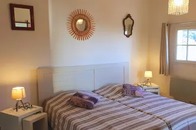 a bedroom with a bed with two lamps and a mirror at Villa U Rustincu Vue mer Acces plage Ruppione Pietrosella in Pietrosella