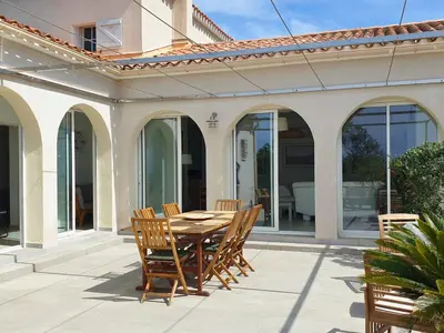 a patio with a wooden table and chairs at Villa U Rustincu Vue mer Acces plage Ruppione Pietrosella in Pietrosella