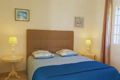 a bedroom with a blue bed with two pillows at Villa U Rustincu Vue mer Acces plage Ruppione Pietrosella in Pietrosella