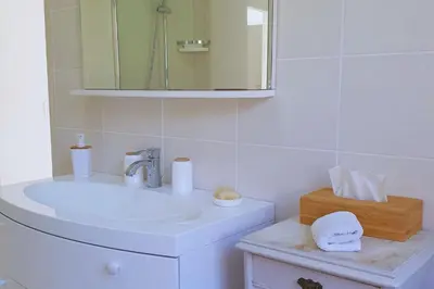 a white bathroom with a sink and a mirror at Villa U Rustincu Vue mer Acces plage Ruppione Pietrosella in Pietrosella