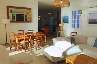 a living room with a table and a couch at Villa U Rustincu Vue mer Acces plage Ruppione Pietrosella in Pietrosella