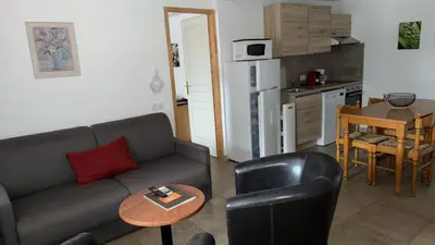 a living room with a couch and a table and a kitchen at Appartement Porto - Ota in Porto Ota