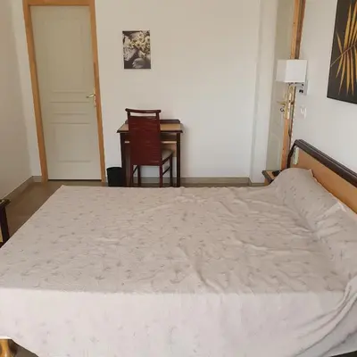 a bedroom with a large bed and a table at Appartement Porto - Ota in Porto Ota