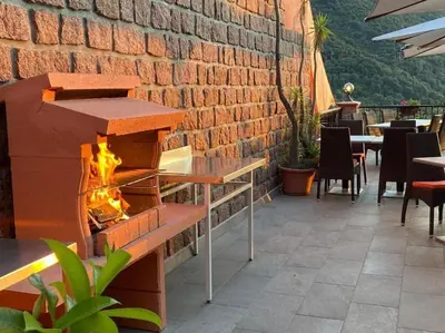 a fire pit on a patio with tables and chairs at Appartement Porto - Ota in Porto Ota