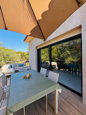 a dining room with a table and chairs on a patio at Appartement paisible au cœur des oliviers, à deux pas de Bonifacio in Bonifacio