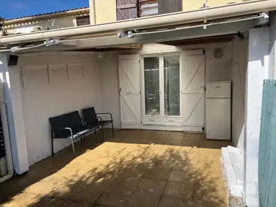 a patio with a table and a chair and a refrigerator at Pavillon chez Michel corse in Poggio-Mezzana