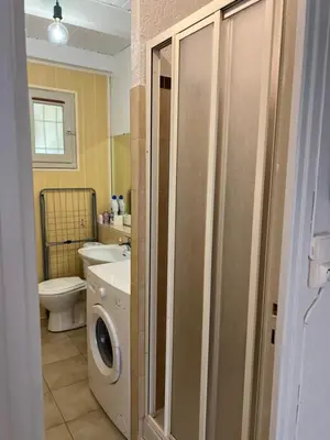 a bathroom with a washing machine and a washer at Pavilllon en corse chez Michel in Poggio-Mezzana