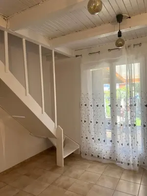 a living room with a staircase and a window at Pavilllon en corse chez Michel in Poggio-Mezzana
