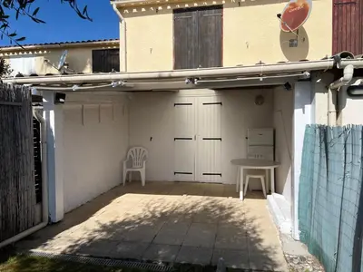a garage with a table and a chair on a patio at Pavilllon en corse chez Michel in Poggio-Mezzana