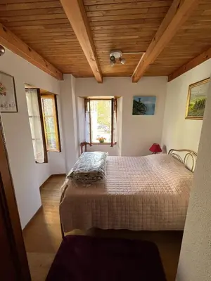a bedroom with a bed in a room with wooden ceilings at Maison de village in Silvareccio