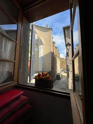 a window view of a street with a bowl of fruit at Maison de village in Silvareccio