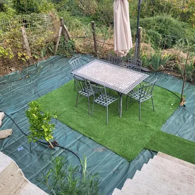 a table and chairs sitting on a lawn withgrass at Maison de village in Silvareccio