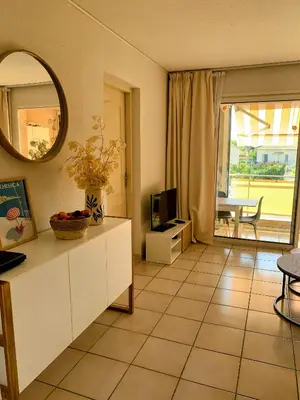 a living room with a tv and a mirror at Chez Aline - Appartement en bord de mer in Cervione