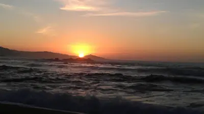 a sunset over the ocean with the sun setting at Villa vue mer 400m plages et commerces calme confort pour 6 à 8 personnes soins de remise en forme possible in Propriano