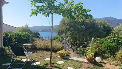 a garden with a tree and a chair and a tree at Villa vue mer 400m plages et commerces calme confort pour 6 à 8 personnes soins de remise en forme possible in Propriano