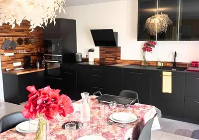a kitchen with a table with red flowers on it at Jardin-Marin-Ajaccio in Ajaccio